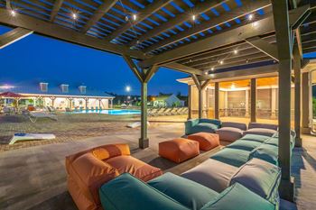 Pool and sundeck with bean bag chairs and pergola